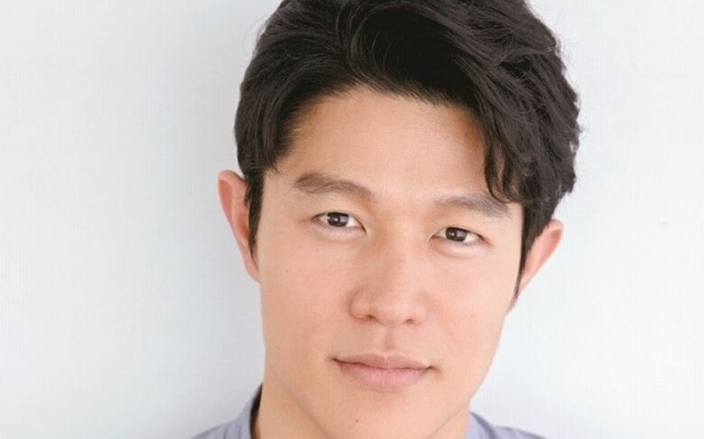 俳優の鈴木亮平が真顔で正面を向いている画像